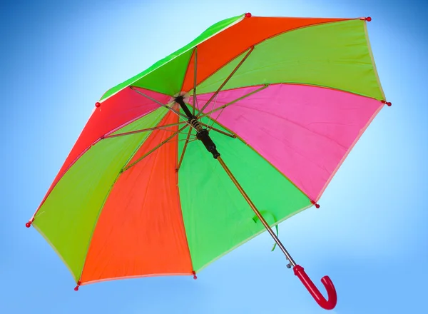 Parapluie multicolore sur fond bleu — Photo