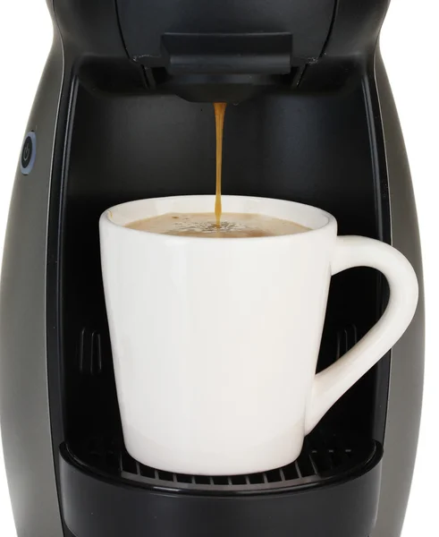 Еспресо-машина заливає каву в білій чашці — стокове фото