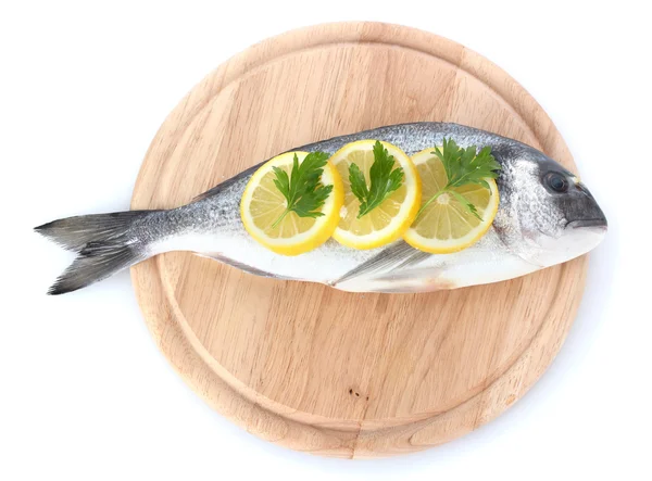 ปลาสดกับมะนาวและผักชีฝรั่งบนกระดานตัดไม้แยกจากสีขาว — ภาพถ่ายสต็อก