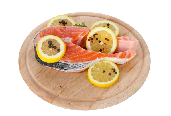 Červená ryba s citronem a koření na dřevěné prkénko, izolované na bílém — Stock fotografie