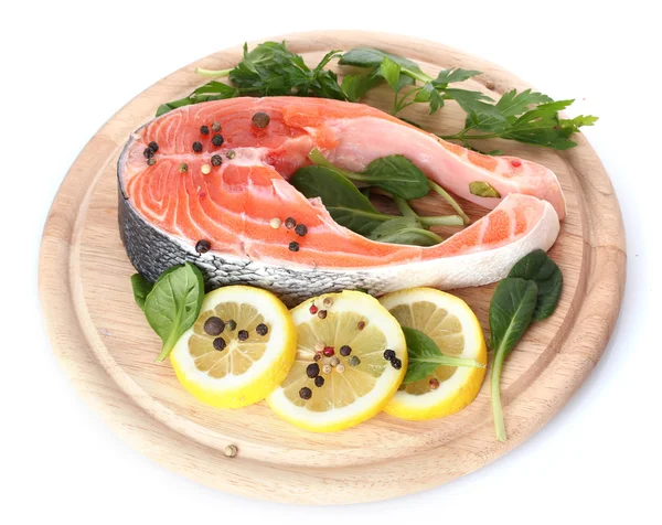 Красная рыба с лимоном и петрушкой на деревянной доске, изолированной на белом — стоковое фото
