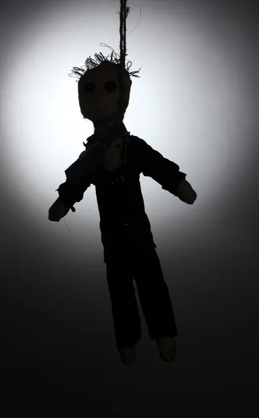 Повішений ляльковий вуду хлопчик-малюк на сірому фоні — стокове фото