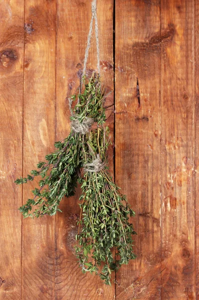 Tomillo verde fresco colgado en la cuerda sobre fondo de madera —  Fotos de Stock
