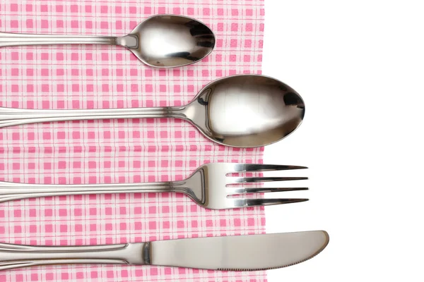 Tenedor, cuchara y cuchillo en un paño a cuadros con un lazo aislado en blanco — Foto de Stock