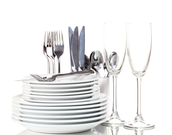 Clean plates, glasses and cutlery isolated on white