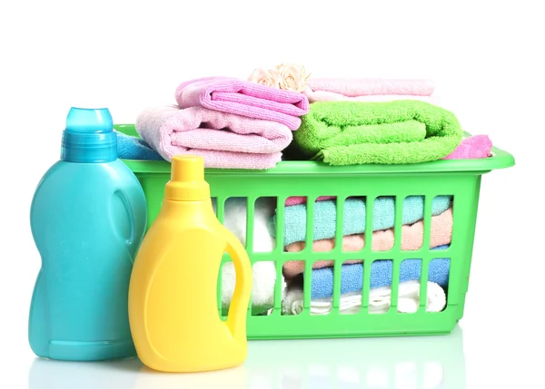 Waschmittel und Handtücher in grünem Plastikkorb isoliert auf weiß — Stockfoto