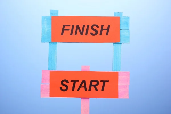 Start, finish wooden boards on blue background — Stock Photo, Image