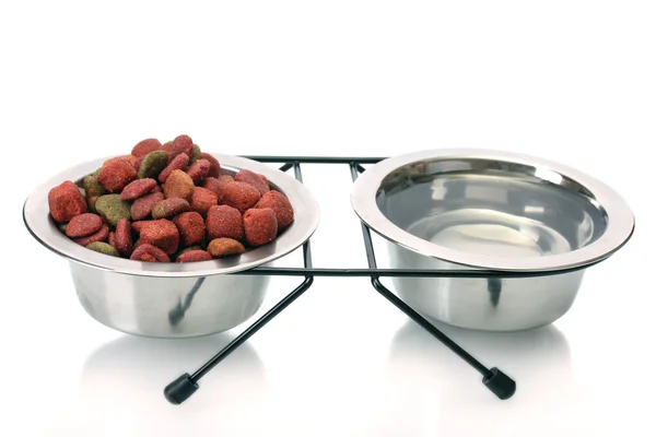 Comida seca para perros y agua en cuencos de metal aislados en blanco —  Fotos de Stock