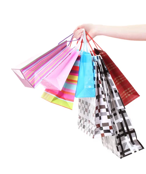 Mano femenina sosteniendo bolsas de compras brillantes aisladas en blanco — Foto de Stock