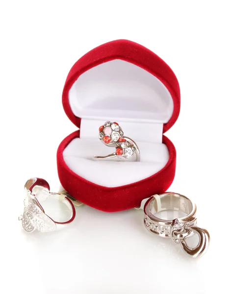 Серебряное кольцо с красными, розовыми и прозрачными кристаллами в красной бархатной коробке и серебряными кольцами, изолированными на белом — стоковое фото