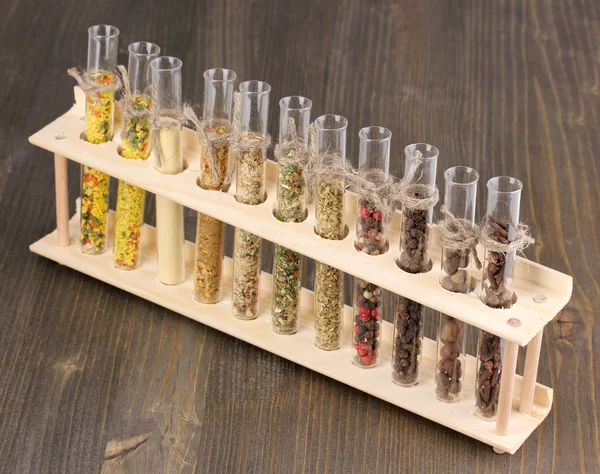 Various spices in tubes on wooden background — Stock Photo, Image