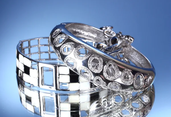 stock image Beautiful silver bracelets on blue background