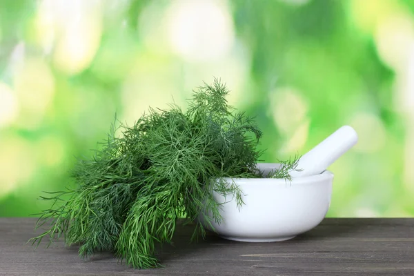 stock image Dill in a mortar and pestle on green background