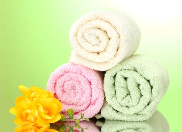 Kolorowe ręczniki i kwiaty na zielonym tle żółty — Zdjęcie stockowe