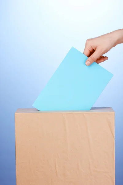 투표 투표와 파란색 배경에 상자 손 — 스톡 사진