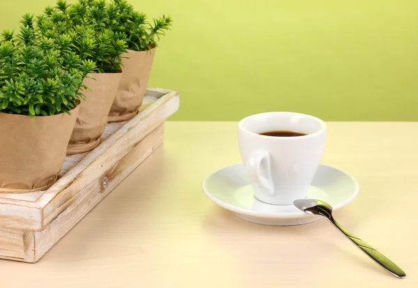 Coffee cup on table in cafe on green background — Stock Photo, Image