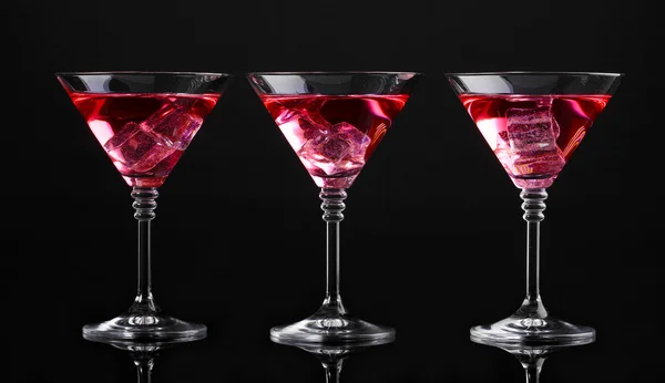 Cóctel rojo en vasos de martini aislados en negro — Foto de Stock