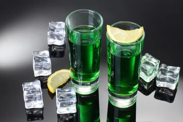 Zwei Gläser Absinth, Zitrone und Eis auf grauem Hintergrund — Stockfoto