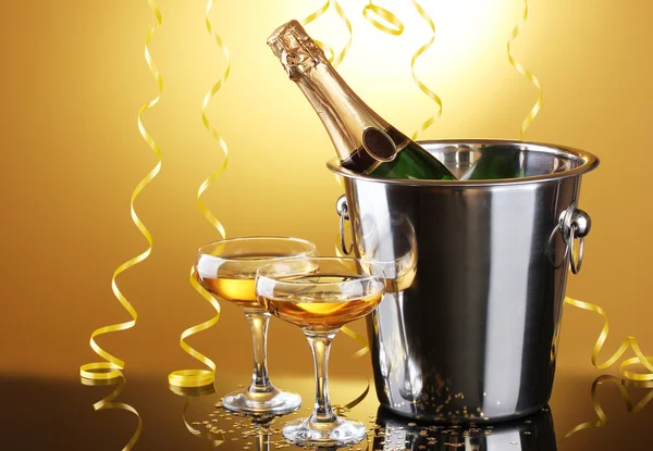 与冰和眼镜的香槟，在黄色背景上的存储桶中的香槟瓶 — 图库照片