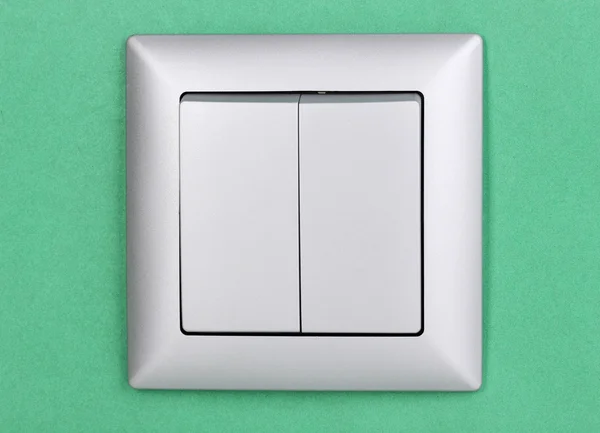 Modern light switch on green background — Stock Photo, Image