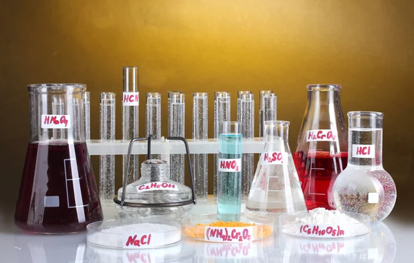 Пробирки с различными кислотами и химикатами на ярком фоне — стоковое фото