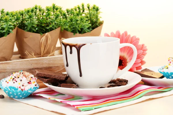 Dirty cup of coffee and gerbera beans, cinnamon sticks on wooden table — Stock Photo, Image