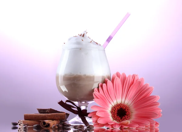 Glass of coffee cocktail and gerbera flower on purple background — Stock Photo, Image
