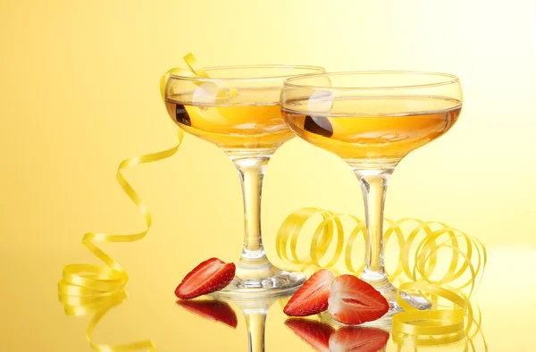 Glas champagne och jordgubbar på gul bakgrund — Stockfoto