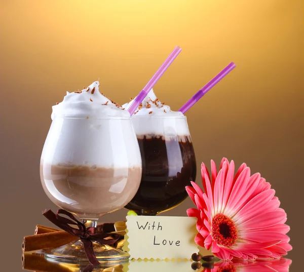 Glasses of coffee cocktail and gerbera flower on brown background — Stock Photo, Image