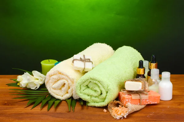 Spa setting on wooden table on green background — Stock Photo, Image