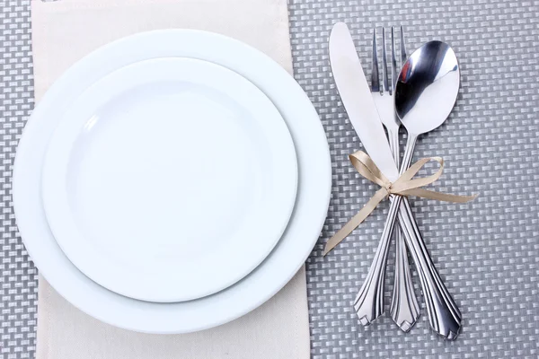 与叉子、 勺子和刀用灰色的桌布上丝带绑白空板 — 图库照片