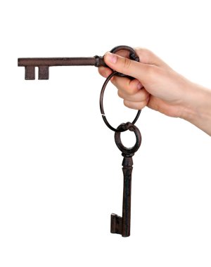 Woman's hand holding an antique key on white background clipart