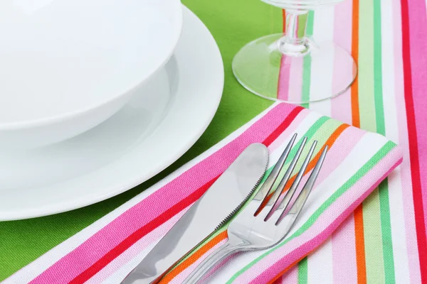 Накрытие стола вилкой, ножом, тарелками и салфеткой — стоковое фото