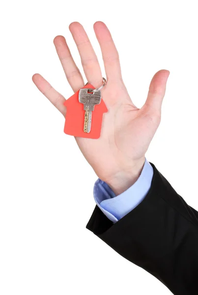 Ключ с домашним шармом в руке, изолированный на белом — стоковое фото