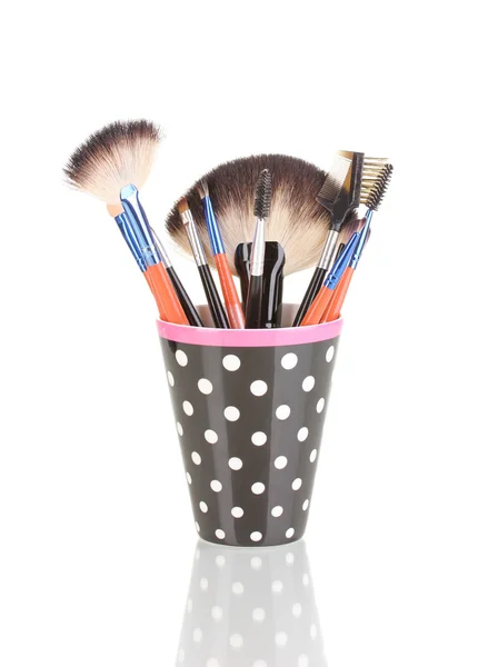Stock image Makeup brushes in a black polka-dot cup isolated on white