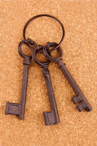 Куча антикварных ключей на пробковом фоне — стоковое фото