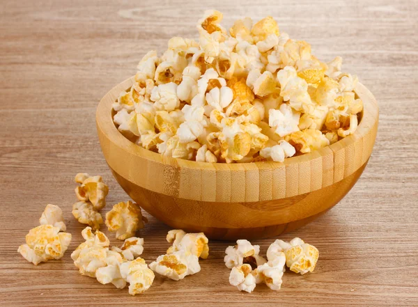 Popcorn w drewniane miski na drewnianym stole — Zdjęcie stockowe