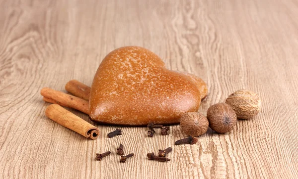 Biscotti a forma di cuore con cannella, noce moscata e garofano su sfondo di legno — Foto Stock