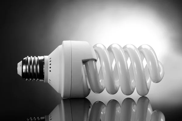 Lampada a risparmio energetico su sfondo grigio — Foto Stock
