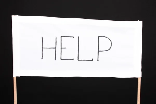 Help written on white cloth isolated on black — Stock Photo, Image