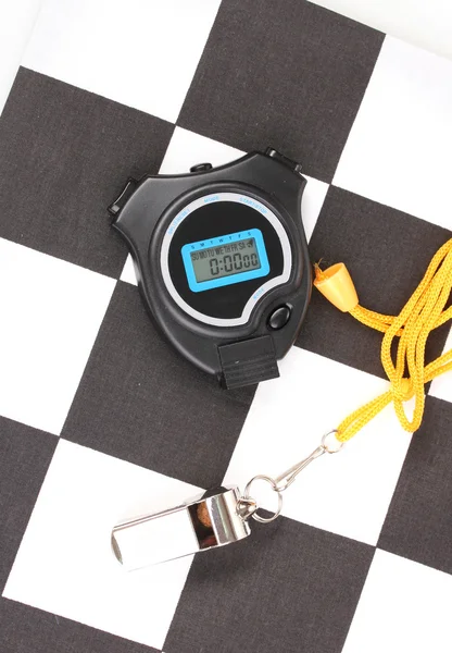 Checkered finish flag with whistle and stopwatch close-up — Stock Photo, Image