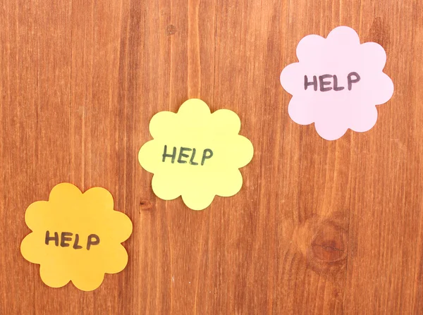 Help written on stickers on wooden background — Stock Photo, Image