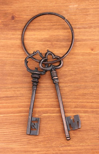 Um monte de chaves antigas em fundo de madeira — Fotografia de Stock