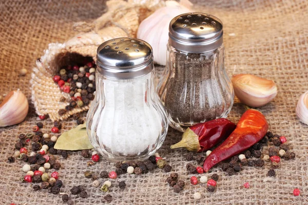 塩と胡椒ミルズと黄麻布の背景にスパイス — ストック写真