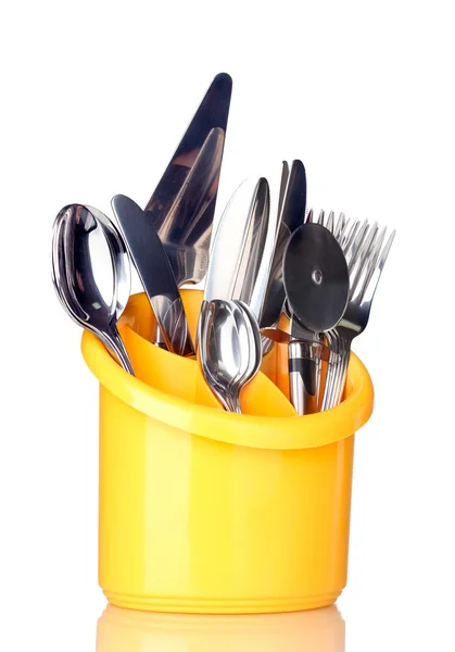Couverts de cuisine, couteaux, fourchettes et cuillères en stand jaune isolé sur blanc — Photo