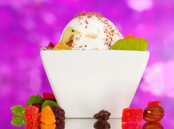 Delicioso helado de vainilla con chocolate y frutas en un tazón sobre fondo morado — Foto de Stock