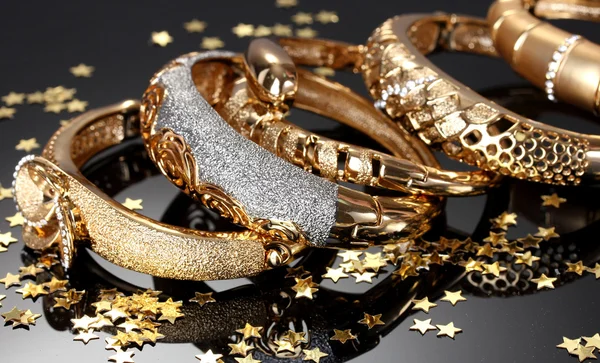 Beautiful golden bracelets on grey background — Stock Photo, Image