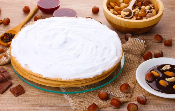 Stock image Cake on glass stand and nuts on wooden table