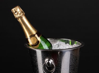 Bottle of champagne in bucket isolated on black clipart