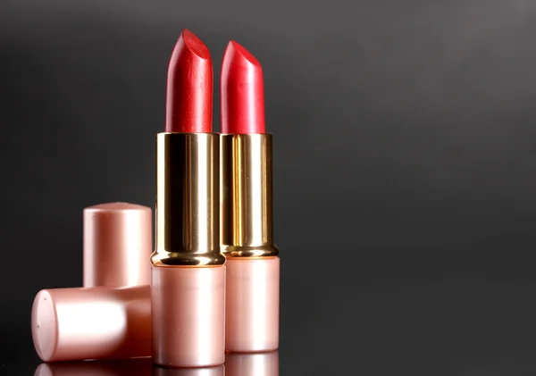 Beautiful red lipsticks on gray background — Stock Photo, Image
